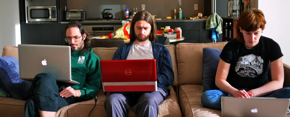 three people sit on couch using laptops